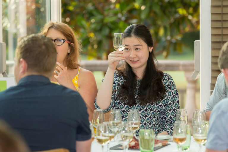 Guest examining white wine at a wine tasting in London