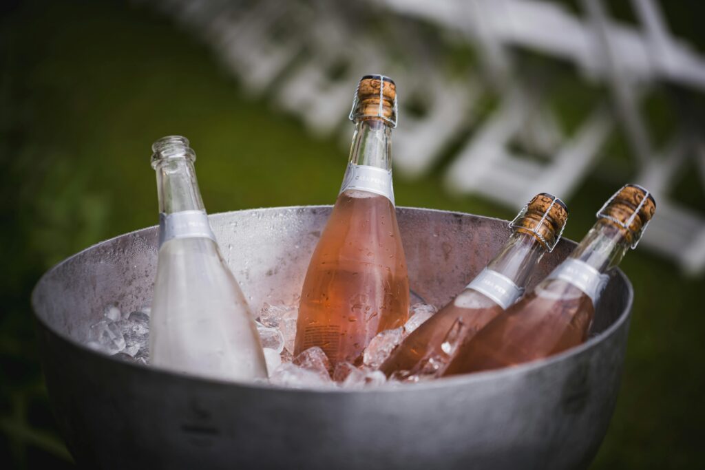 Three full bottles of Rose sparkling wine, and one empty in a metal icebucket at a Champagne & Sparkling Wine Masterclass