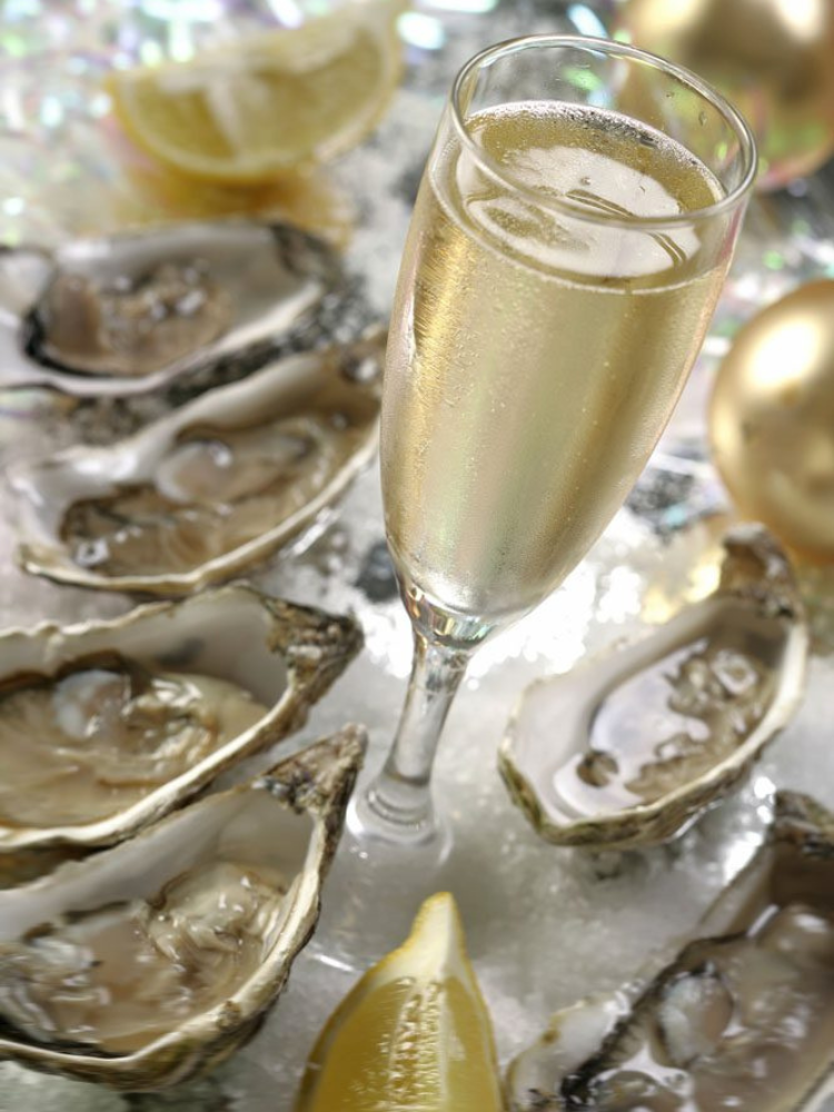 A flute of sparkling wine surrounded by oysters and lemon wedges at a one day wine course